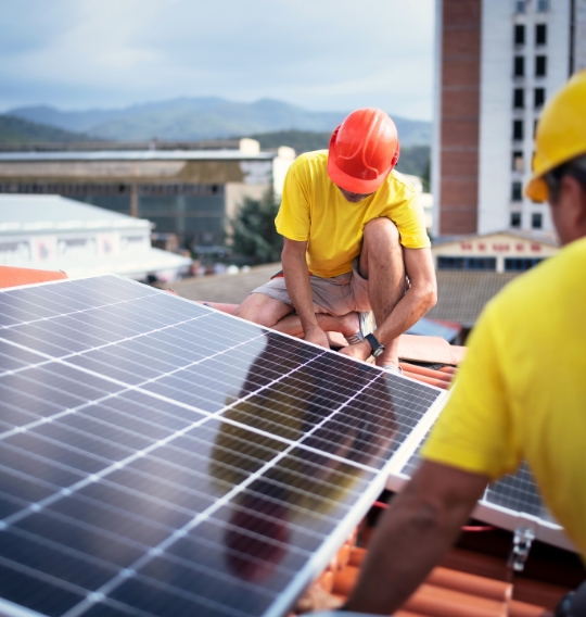 Dvaja muži stavajúci fotovoltaický panel